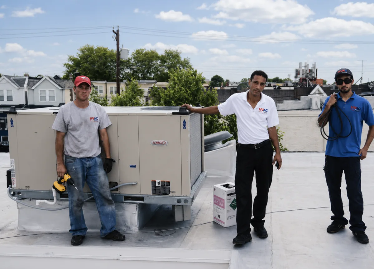 The HVAC Philly crew on a Philadelphia rooftop beside a Lennox commercial rooftop unit